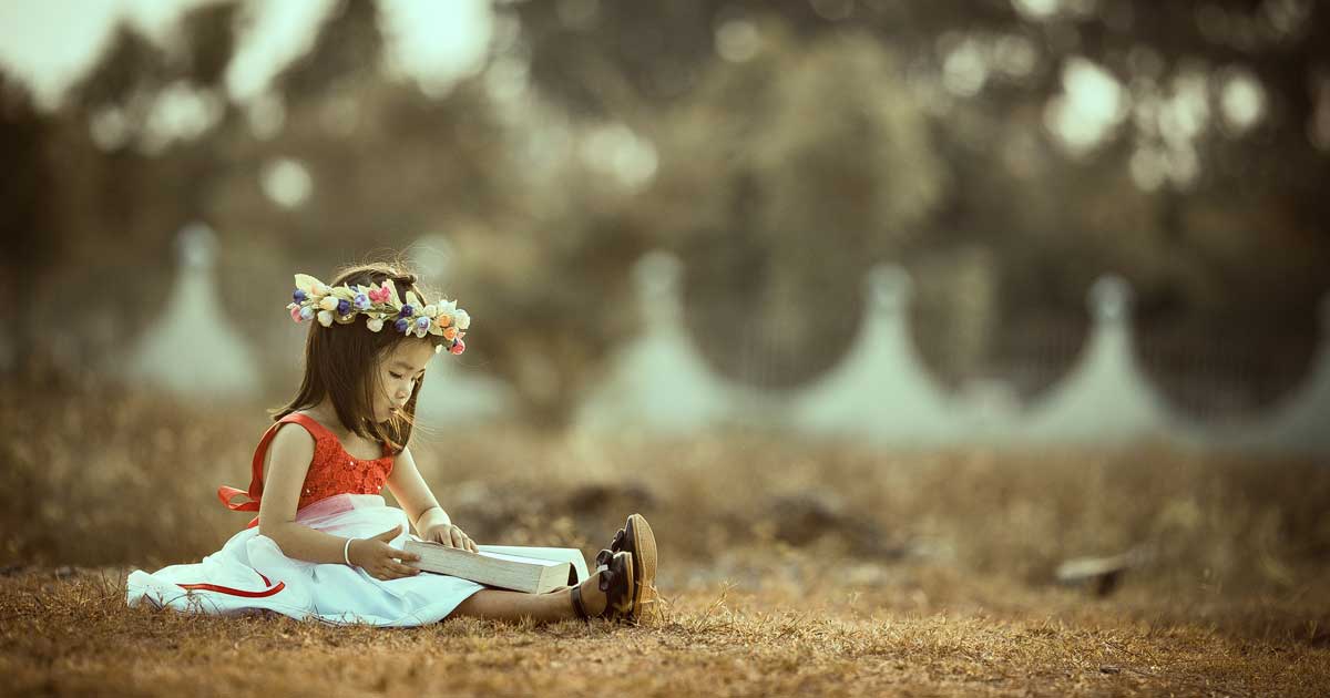girl reading book outdoors